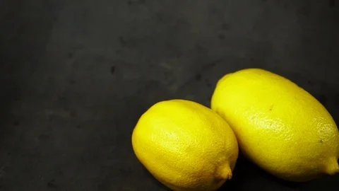 Two yellow lemons on a black background. citrus composition. Stock Footage 99500809