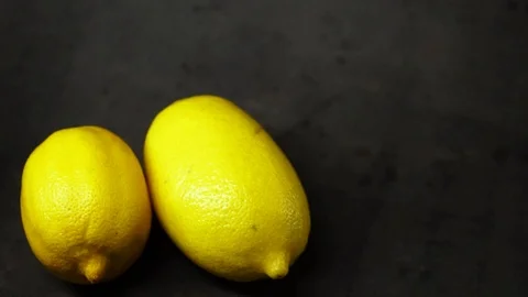 Two yellow lemons on a black background. citrus composition. Stock Footage 99500813