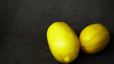 Two yellow lemons on a black background. citrus composition. Stock Footage 99500823
