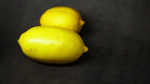 Two yellow lemons on a black background. citrus composition. Stock Footage 99500824