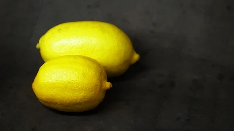 Two yellow lemons on a black background. citrus composition. Stock Footage 99500826