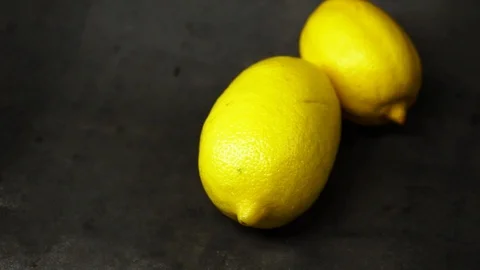 Two yellow lemons on a black background. citrus composition. Stock Footage 99500829