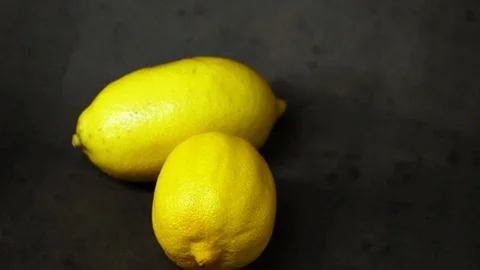 Two yellow lemons on a black background. citrus composition. Stock Footage 99500830