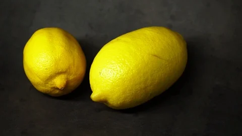 Two yellow lemons on a black background. citrus composition. Stock Footage 99500833