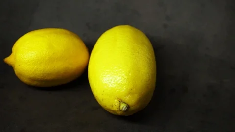 Two yellow lemons on a black background. citrus composition. Stock Footage 99500841