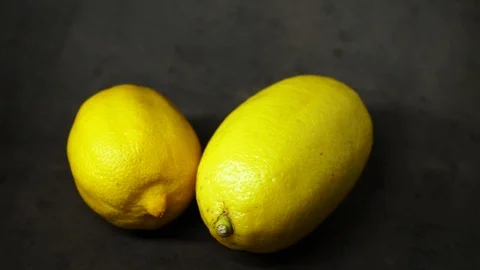 Two yellow lemons on a black background. citrus composition. Stock Footage 99500842