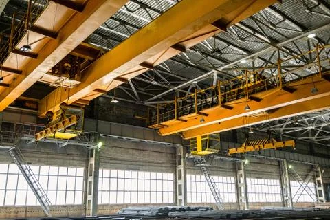 Two yellow overhead cranes in engineering plant shop Stock Photos