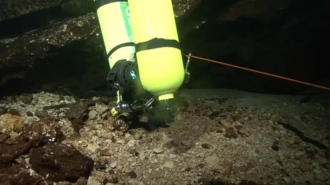 Two yellow oxygen tanks on the sandy bottom in a cave system Stock Footage 83059670