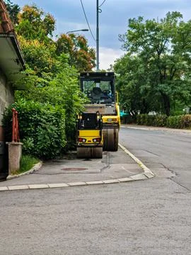Two yellow road rollers parked on the street 写真素材