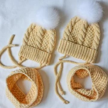 Two yellow sets of caps with a fluffy bobble and Snood Stock Photos