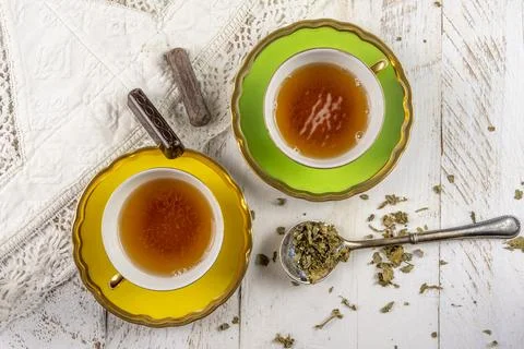 Two yellow tea cup on a white wooden background Foto stock