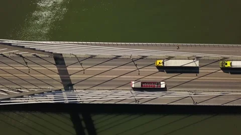 Two yellow trucks with white trailers are driving across the bridge. Stock Footage 130497080