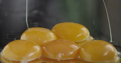 Two yolks fall to three yolks on a mirror surface Stock Footage 200255333