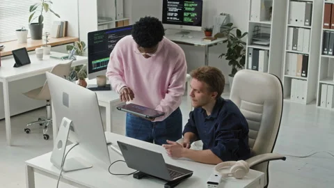 Two Young Adult Programmers Collaborating on Code Debugging at Computer Desk Stock-Footage 330126472