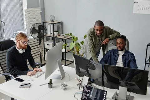 Two young African American programmers discussing online data on computer screen Stock-Fotos