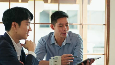 Two young architects sharing new idea and working on new construction project in Stock Footage 266418830