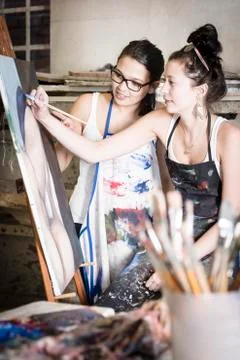 Two young artists working together on a painting Stock Photos