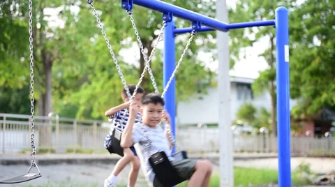 Two young asian boy play a iron chain swinging at the playground  Stock Footage 64816786