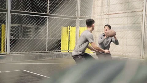 Two young asian men playing basketball outdoors Vidéo 150006550