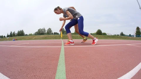 Two young athlete man and woman start running at athletics track during a day Stock Footage 104879568