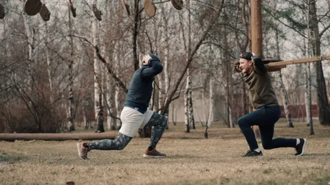 Two young athletes doing lunges exercises in motion on park in spring day. Video stock 130810970