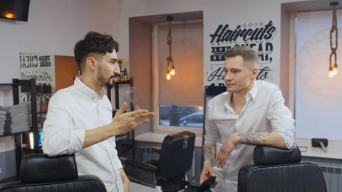 Two young barbers communicating in empty barber shop Stock Footage 128809682