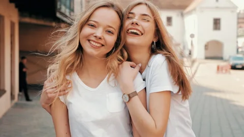 Two young beautiful blond smiling hipster girls Stock Footage 141221806
