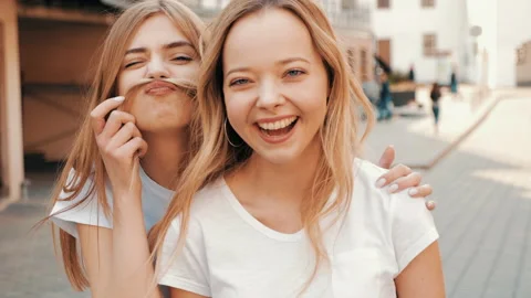 Two young beautiful blond smiling hipster girls Stock Footage 141222201