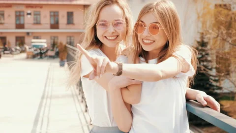 Two young beautiful blond smiling hipster girls Stock Footage 141242643