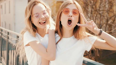 Two young beautiful blond smiling hipster girls 库存影片 141242782