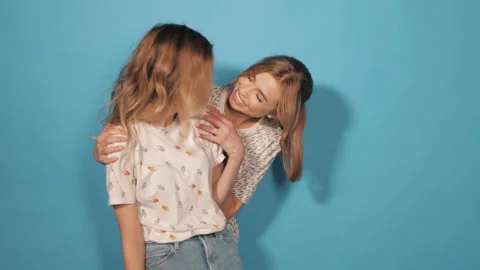 Two young beautiful blond smiling hipster girls in trendy summer clothes Stock Footage 141936942