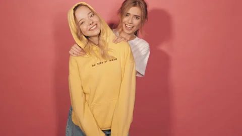 Two young beautiful blond smiling hipster girls in trendy summer clothes Stock Footage 141973376