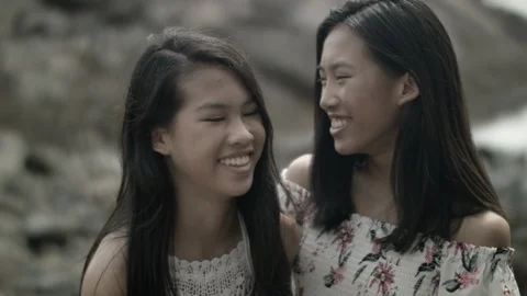 Two young beautiful happy women with long dark hair smiling at each other Stock Footage 94151453