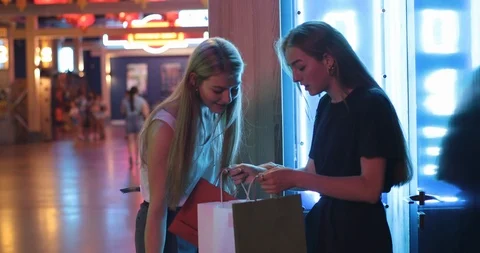 Two young beautiful lady walking after successful shopping, they smile and carry Stock Footage 112688737