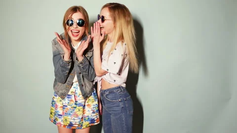 Two young beautiful smiling hipster girls in trendy summer casual clothes Stock Footage 140870708