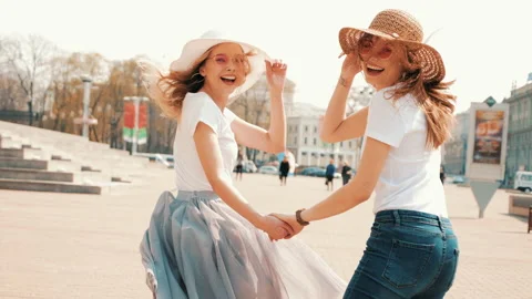 Two young beautiful smiling hipster girls in trendy clothes Stockbeeldmateriaal 141218535