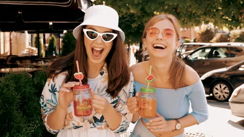 Two young beautiful smiling hipster girls in trendy summer clothes 動画素材 141570526