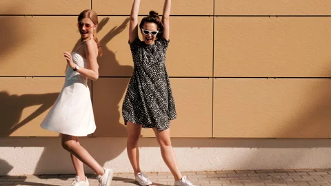 Two young beautiful smiling hipster girls in trendy summer clothes Stock Footage 141573251