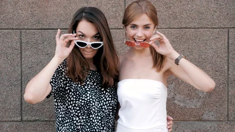 Two young beautiful smiling hipster girls in trendy summer dresses Stock Footage 141603353