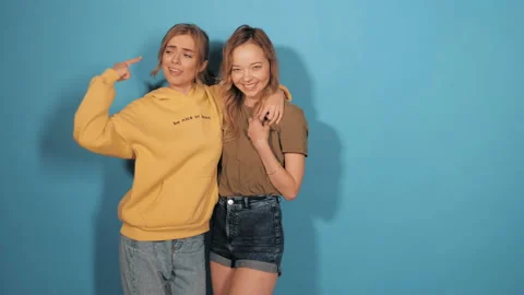 Two young beautiful smiling hipster girls in trendy summer clothes Vidéo 141980132