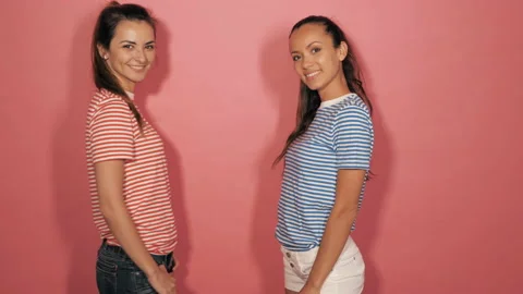 Two young beautiful smiling hipster girls in trendy summer  clothes Stock Footage 142015118