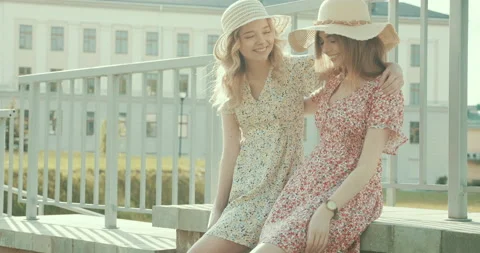 Two young beautiful smiling hipster girls in trendy dresses Stock Footage 142263971