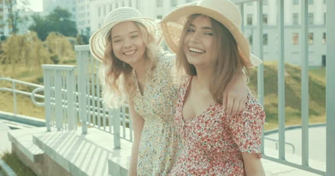 Two young beautiful smiling hipster girls in trendy summer sundress Stock Footage 142265201