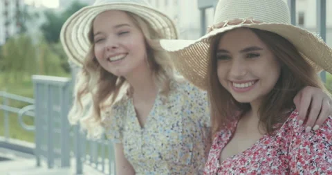 Two young beautiful smiling hipster girls in trendy summer sundress Stock Footage 142265867