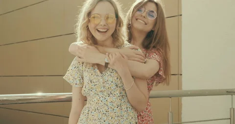 Two young beautiful smiling hipster girls in trendy summer sundress Stock Footage 142272879
