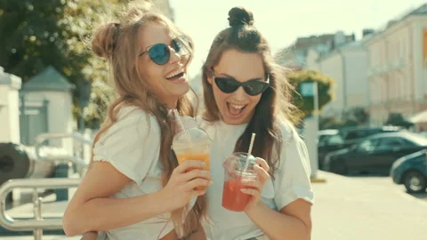 Two young beautiful smiling hipster women in trendy summer clothes Stock Footage 142349904