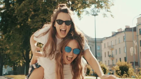 Two young beautiful smiling hipster girls Stock Footage 142373315