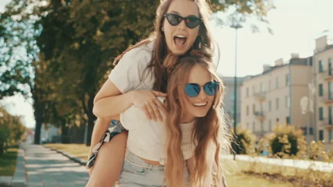 Two young beautiful smiling hipster girls Stock Footage 142374793