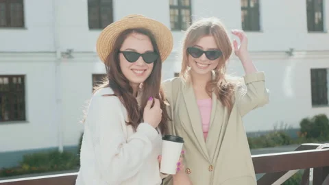 Two young beautiful smiling hipster girls in trendy white sweater and coat Stock Footage 142522210