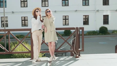 Two young beautiful smiling hipster girls in trendy white sweater and coat Stock Footage 142522326